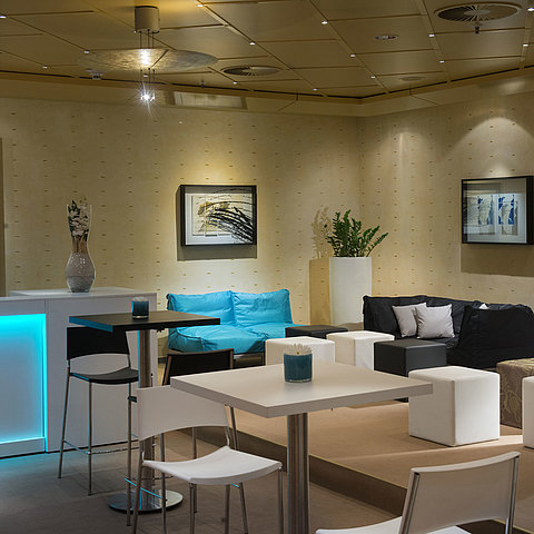 Modern lounge with seating and bar at the Maritim proArte Hotel Berlin, ideal for meetings and networking.