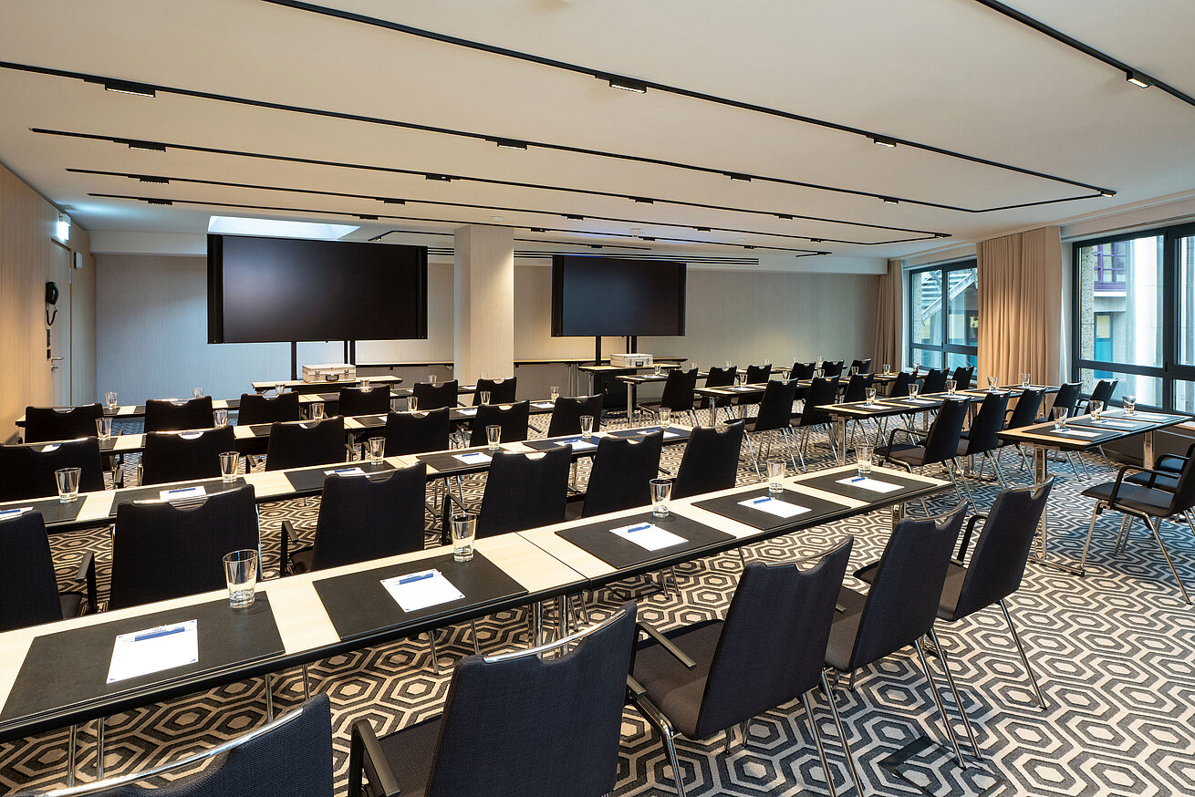 Meeting room 1 with classroom-style seating, conference tables, modern media technology and bright interior.