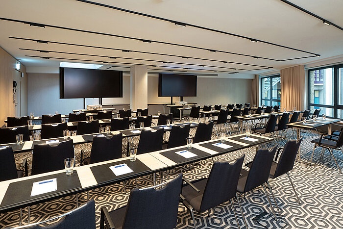 Meeting room 1 with classroom-style seating, conference tables, modern media technology and bright interior.