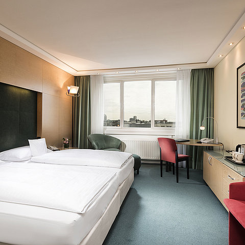 Comfort room at Maritim proArte Hotel Berlin with double bed, desk, chair, and city view.