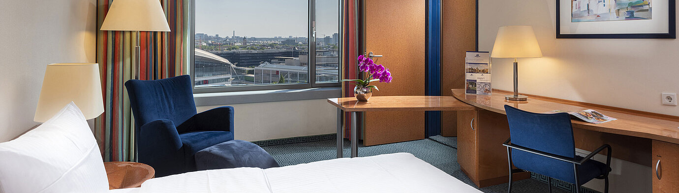 Comfort Family room Comfort family room at Maritim Hotel Frankfurt with double bed, desk, colorful curtains, and city view.