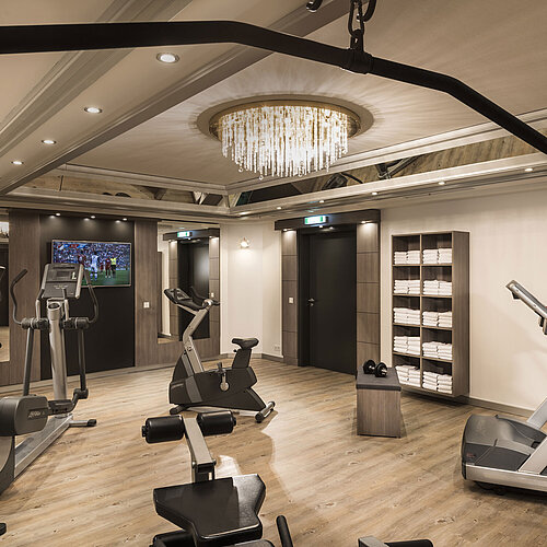 Well-equipped fitness room with cardio machines and mirrors at the Maritim Hotel Munich