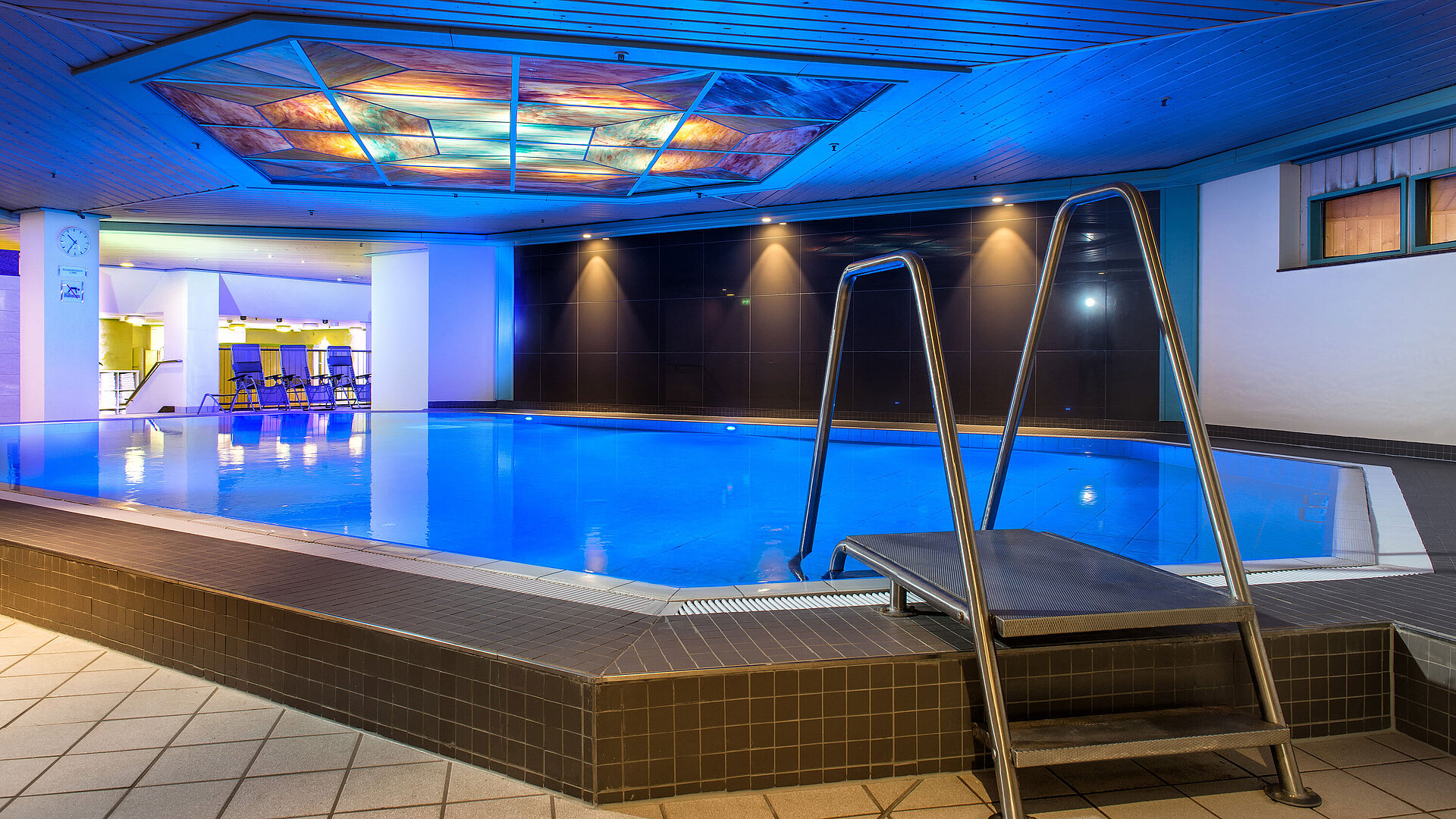 The illuminated indoor pool at Maritim Hotel, inviting relaxation and recreation.
