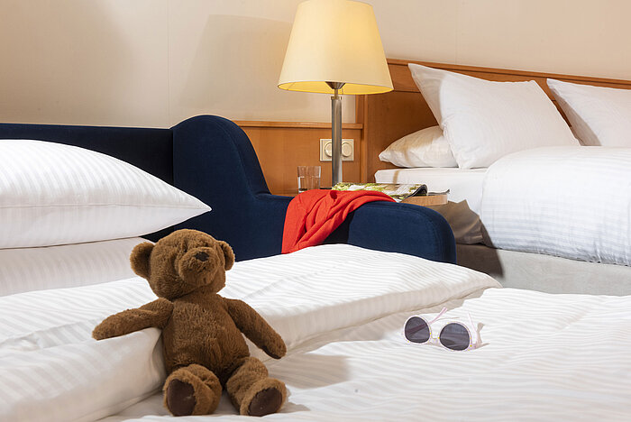 Classic Family room Cozy family room at Maritim Hotel Frankfurt with a teddy bear, sunglasses, and soft beds for a relaxing stay.