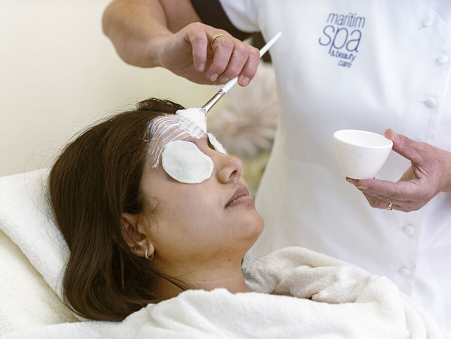 Facial treatment at the Maritim Hotel Spa: A woman receives a face mask and relaxing care with cotton pads.