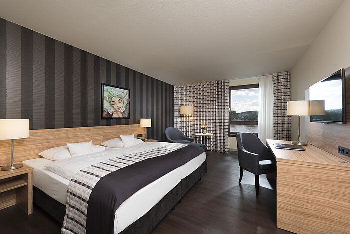 Elegant twin room at Maritim Hotel Königswinter with Rhine view, modern design, and stylish interior.