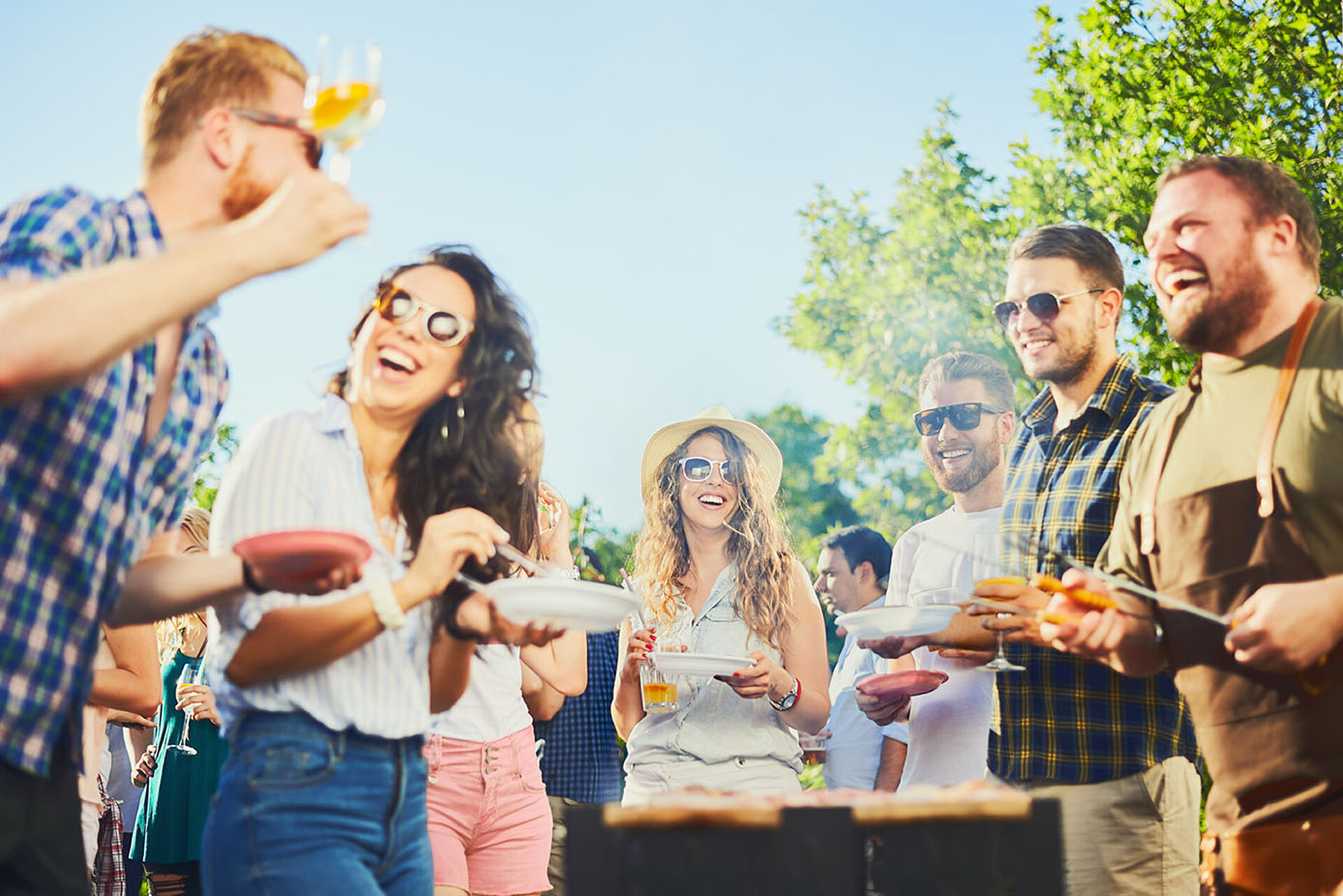 Friends laughing and celebrating together at a summer barbecue outdoors