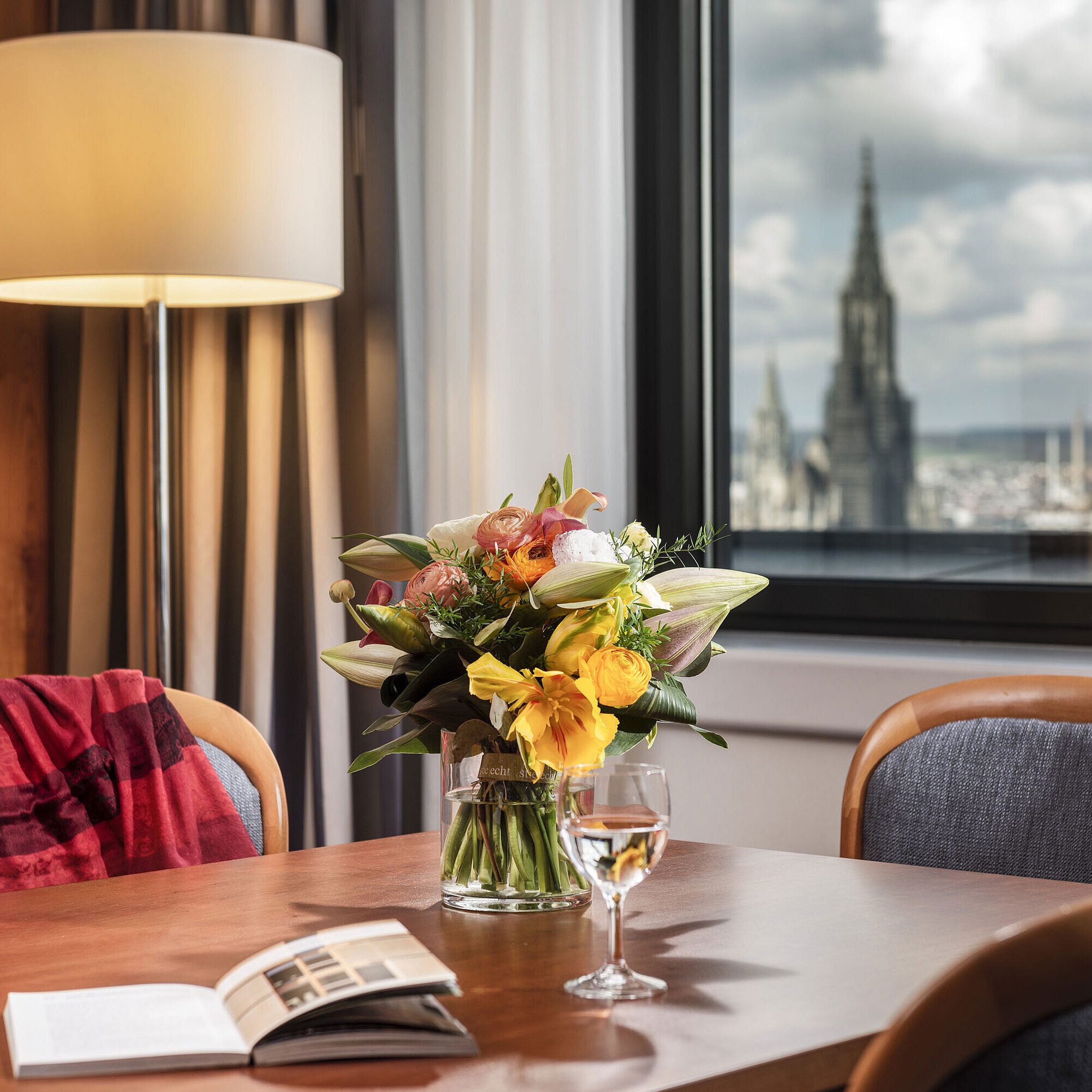 Junior suite Table with flower bouquet in Junior Suite at Maritim Hotel Ulm with a view of Ulm Minster