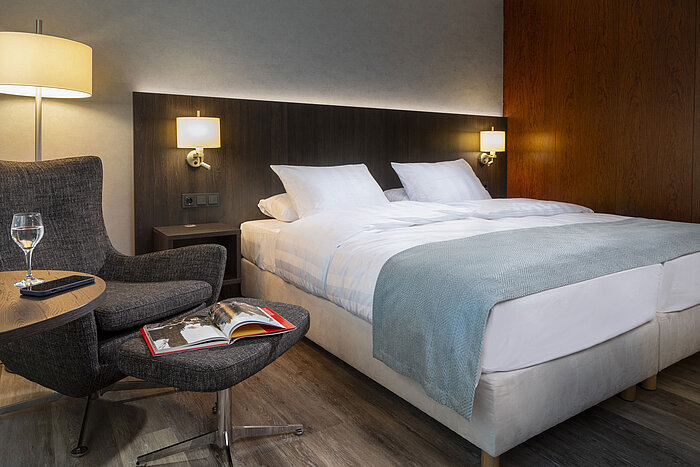 Hotel room for allergy sufferer Elegant Superior double room at Maritim Hotel Bremen with cozy armchair, reading material, and relaxing ambiance.