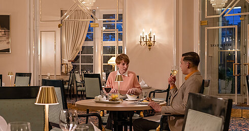 Café-Restaurant "Classic" Guests dining in the Café-Restaurant Classic, enjoying a cosy evening in an elegant, warmly lit setting.