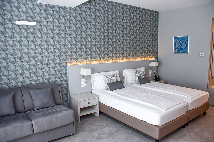Superior room Spacious room at Maritim Resort Calabria with twin bed, sofa and stylish wall design
