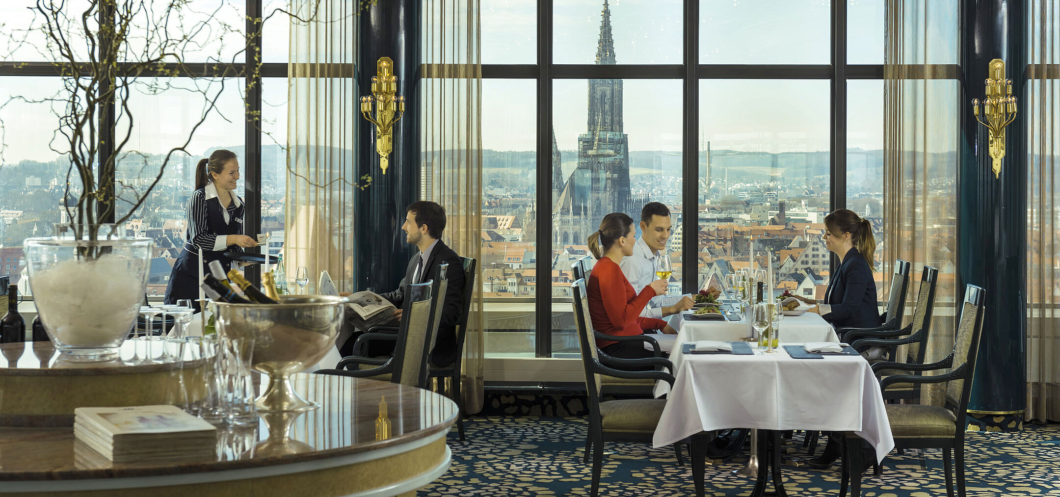 Guests enjoying a meal with a view of Ulm Minster at the panorama restaurant of Maritim Hotel Ulm