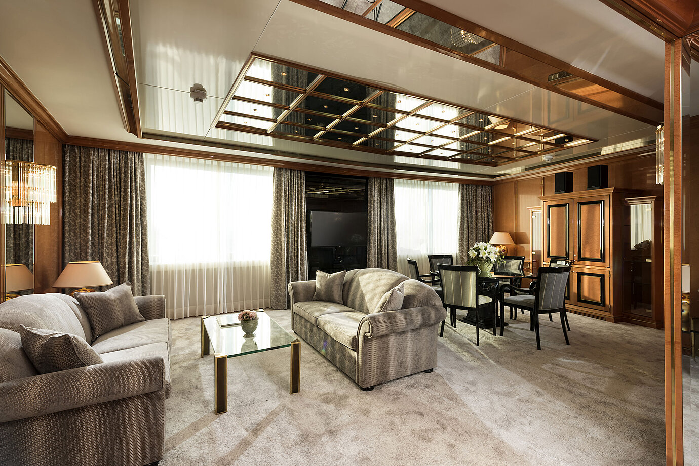 Bright living area of the suite at Maritim Hotel Ulm with sofas, glass table and dining area