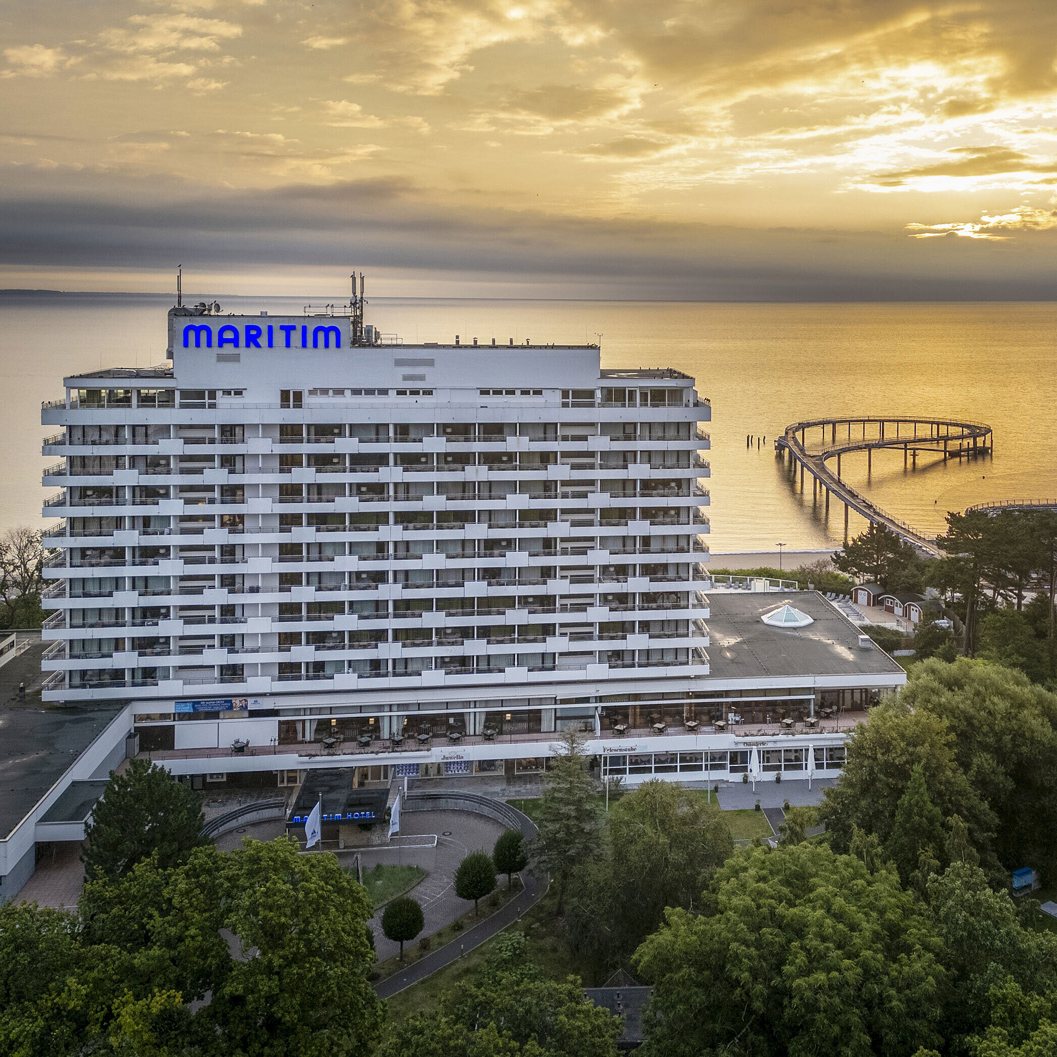 Exterior view Maritim Seehotel Timmendorfer Strand at sunrise with a pier and sea view.