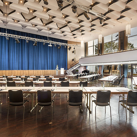 Grand Hall "Maritim" at Maritim Seehotel Timmendorfer Strand with stage, blue curtains, and conference seating.