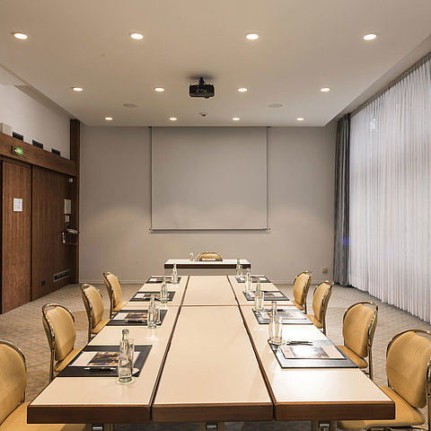 "Salon Bonn" conference room at Maritim Seehotel Timmendorfer Strand with meeting table, natural light, and screen.