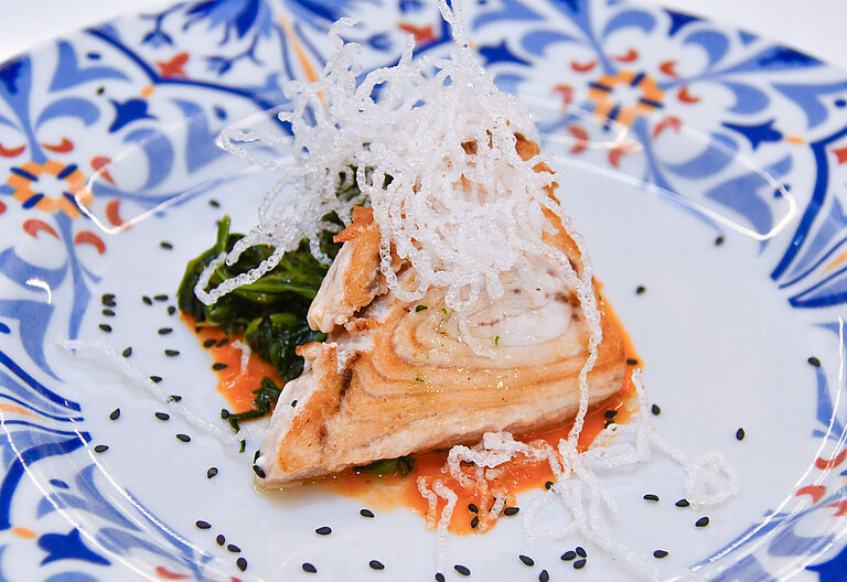 Fish dish Artfully plated fish fillet with vegetables on ceramic plate at Maritim Resort Calabria