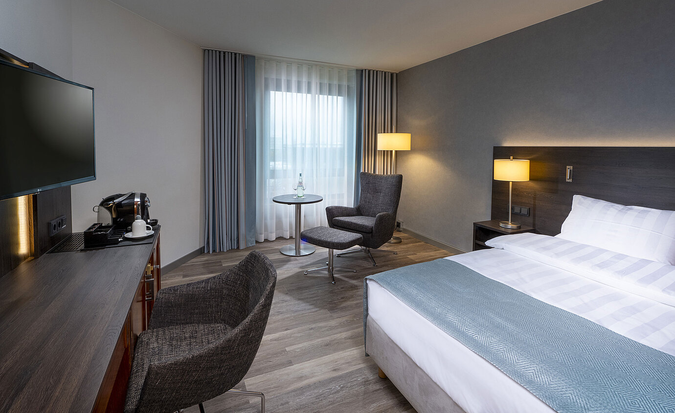 Superior Queen room Modernly furnished Superior Queen room with desk, TV, seating area, and comfortable bed at Maritim Hotel Bremen.