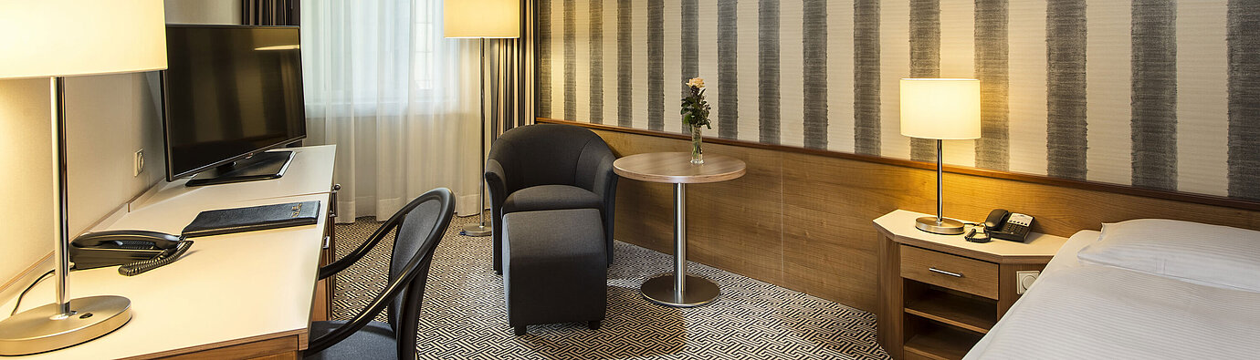 Classic Comfort room Desk with TV and comfortable seating in single room at Maritim Hotel Stuttgart
