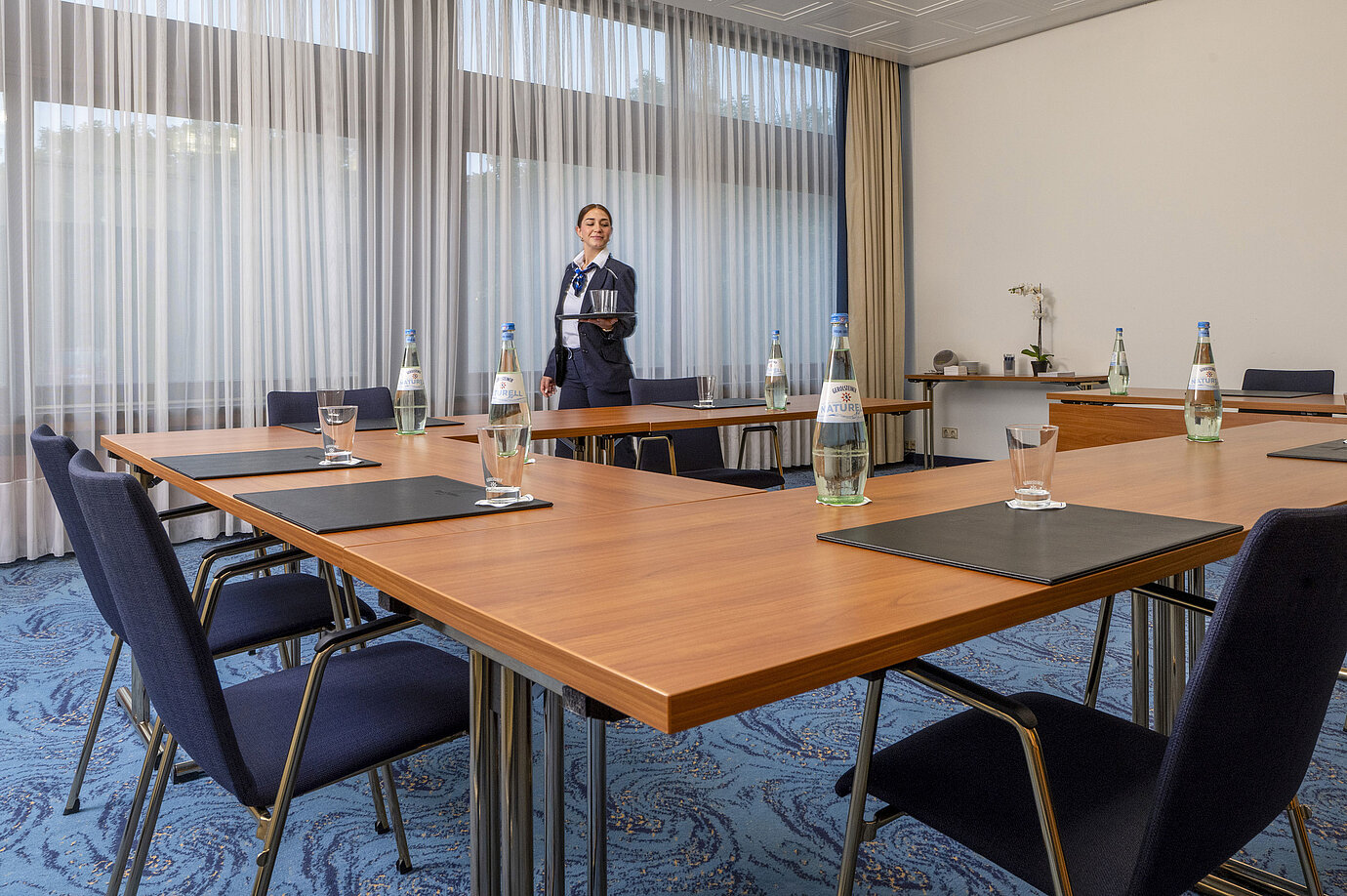 Meeting room with U-shaped seating and friendly Maritim staff member at Maritim Hotel Travemünde