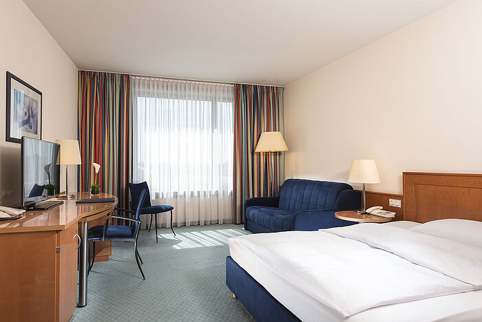 Classic room  Classic room at Maritim Hotel Frankfurt with double bed, desk, sofa, and large windows for natural light.