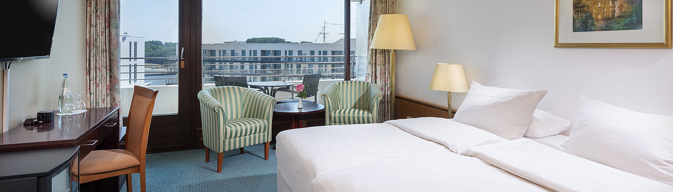 Double room at Maritim Hotel Travemünde with seating area and city view