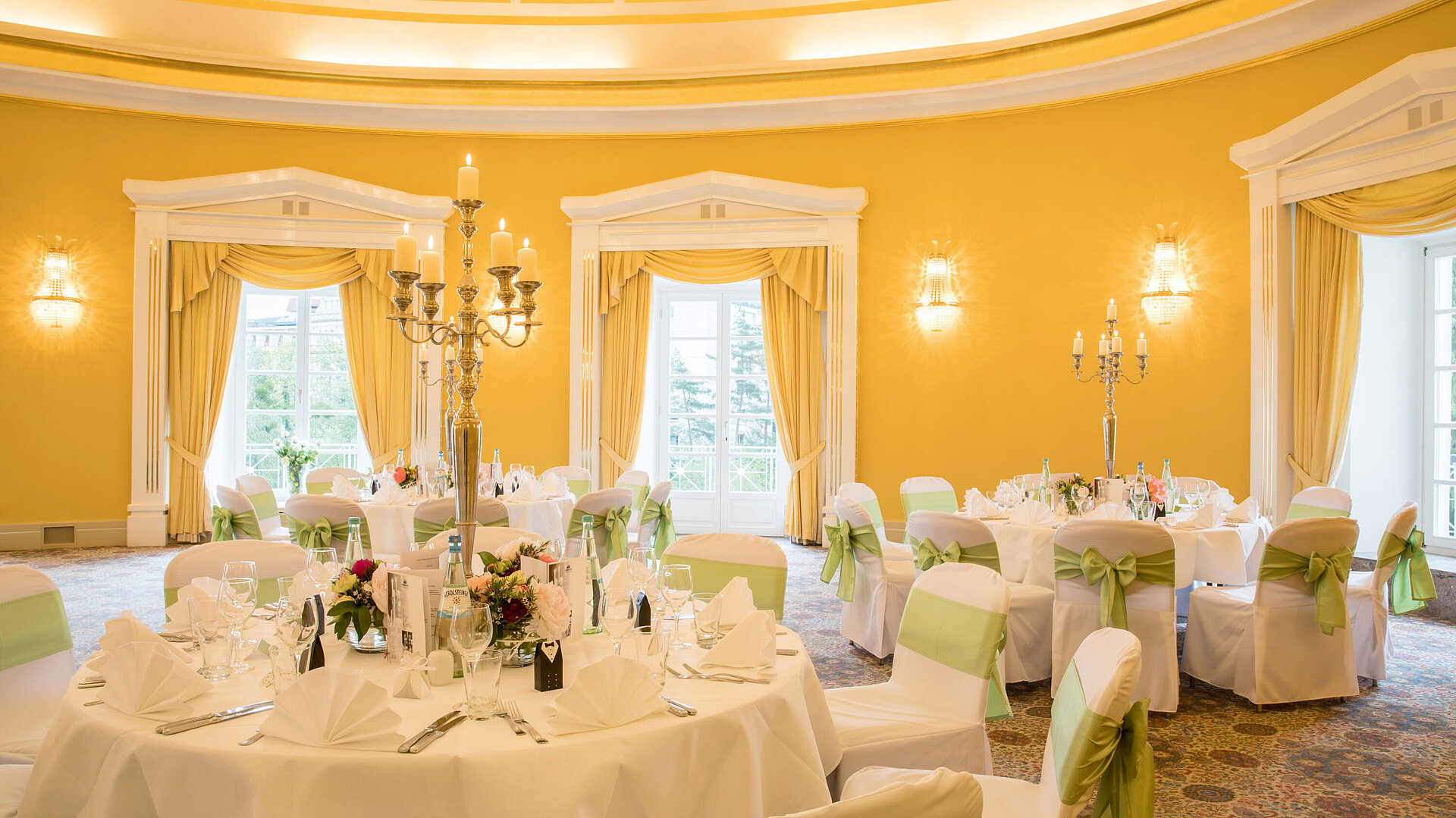 	Banquet hall with white covers and green bows for weddings at Maritim Hotel Bad Wildungen