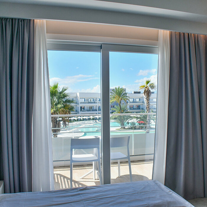 Poolview room View from hotel balcony at Maritim Resort Calabria with pool, palm trees and modern resort