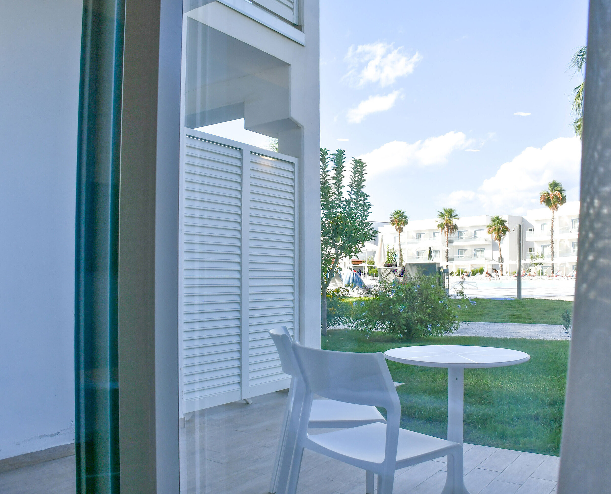 Terrace with garden view Private terrace with table and chairs at Maritim Resort Calabria with view of garden and pool