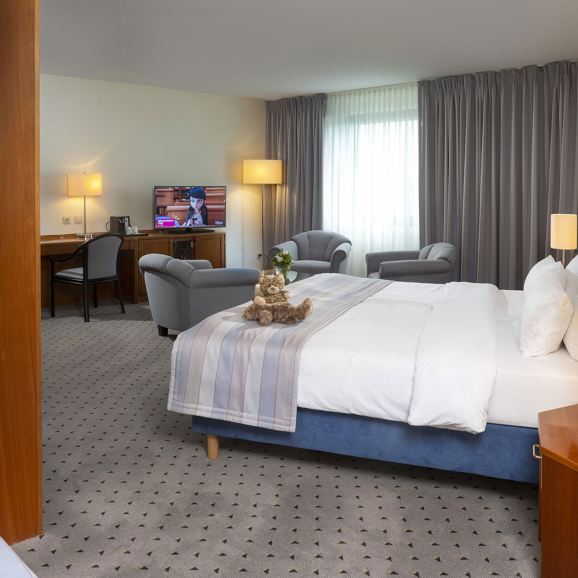 Superior Family room Spacious room at Maritim Hotel Hannover with double bed, seating area, and TV.