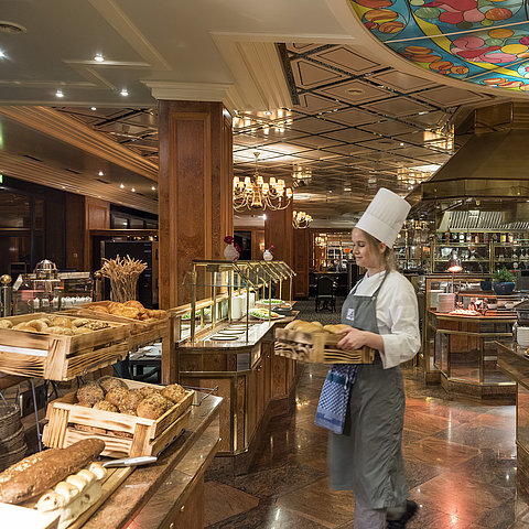 Breakfast buffet at Maritim Hotel Bremen with fresh bread rolls, bread,and a selection of breakfast dishes,attended by a chef