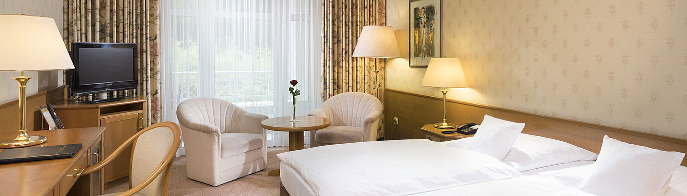 Bright double room with seating area and desk at Maritim Hotel Bad Wildungen