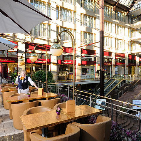 Café Heumarkt at Maritim Hotel Cologne with seating and service staff in a stylish atmosphere.