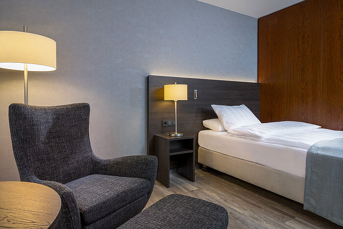 Superior Queen room Modern Superior room at Maritim Hotel Bremen with cozy chair, bedside table, and ambient lighting.