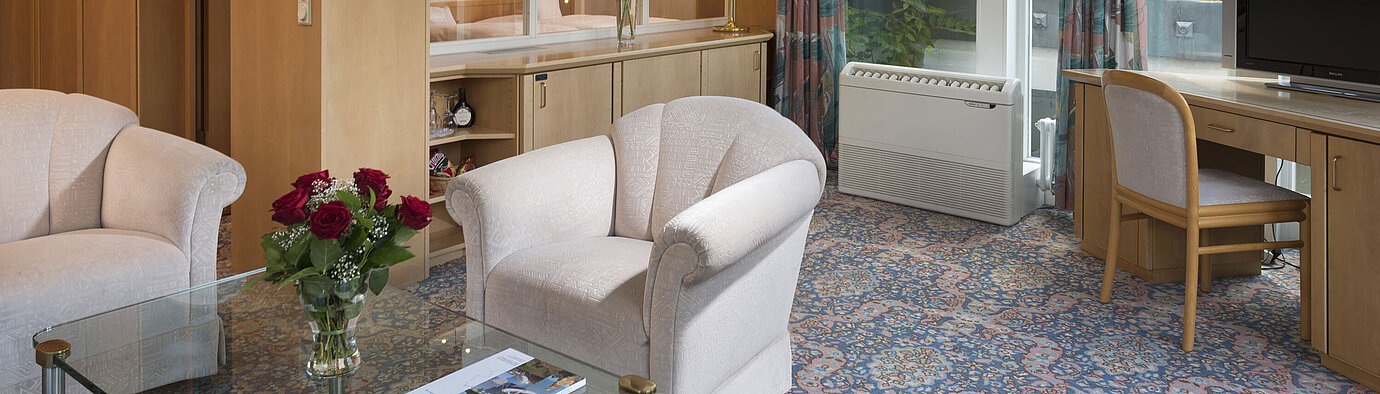 Stylish living area with armchairs, TV, large windows and roof view at Maritim Hotel Bad Wildungen
