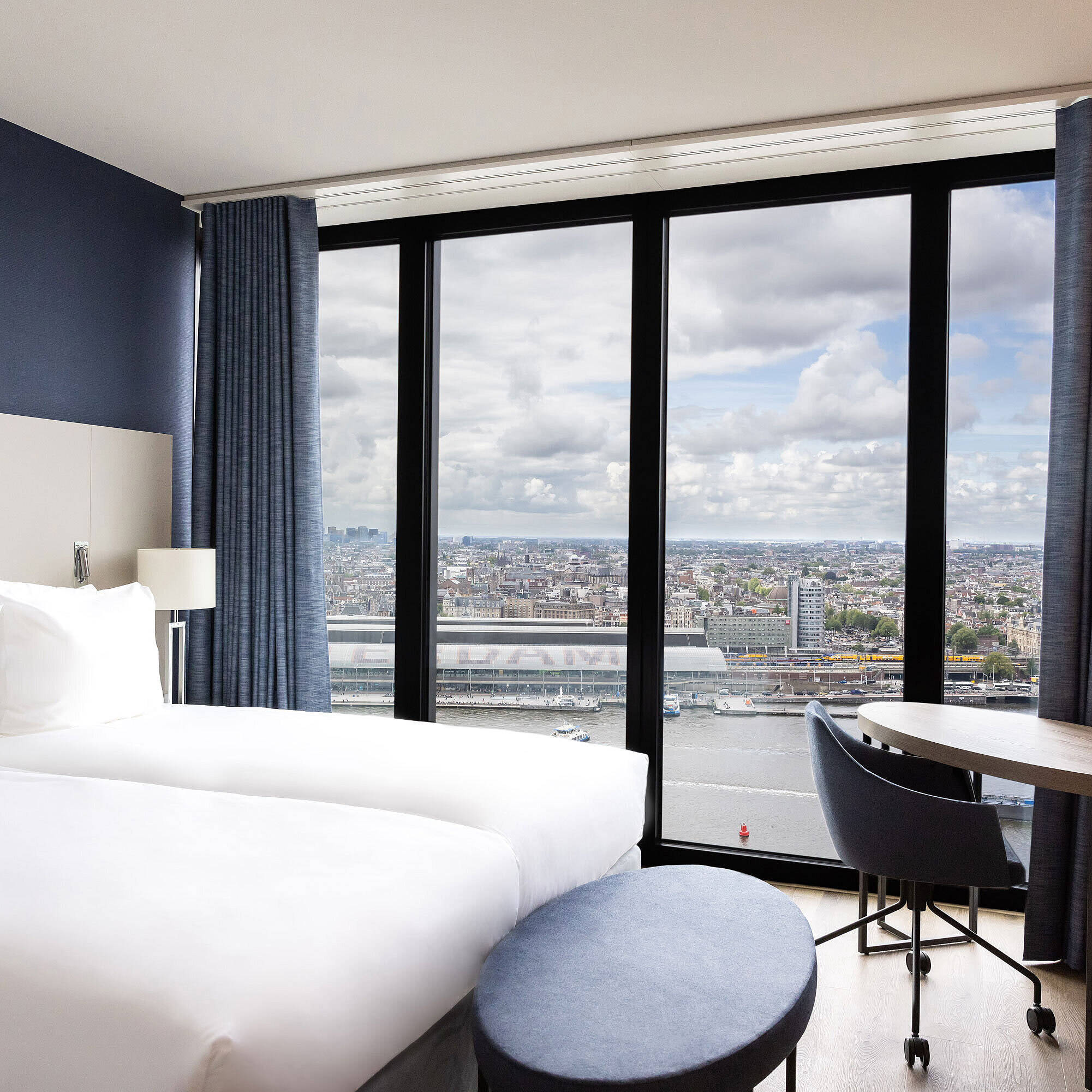 Bedroom with panoramic view Double room with large window and view of Amsterdam at Maritim Hotel