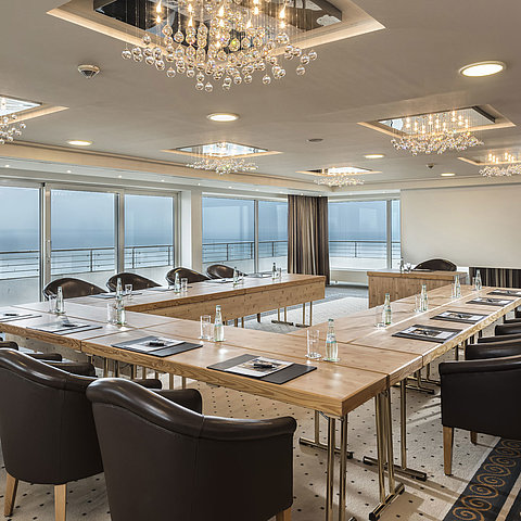 Salon Hamburg at Maritim Seehotel Timmendorfer Strand, conference room with sea view, L-shaped table, and elegant lighting.