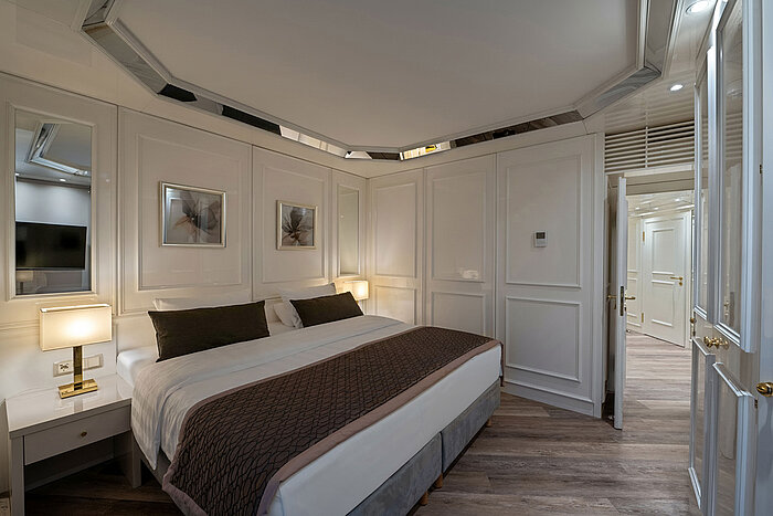 Hotel room bedroom with double bed, bedside tables, warm lighting and a classic interior design.