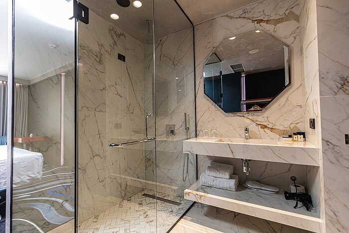 Luxury bathroom at Maritim Resort Marina Bay with marble tiles, shower and mirror