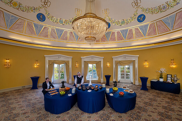 Fürst-Karl Dome Hall with buffet setup, domed ceiling, chandelier and elegantly arranged standing tables.