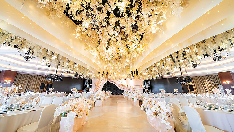 裝飾華美的婚禮大廳，配有花卉天花板設計、典雅舞台及時尚座椅