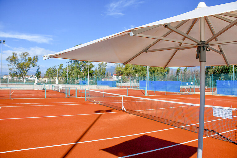 Tennis court  Sunshade at the red tennis court of Maritim Resort Calabria invites to sporty relaxation outdoors