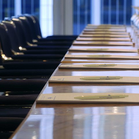 Close-up of a prepared conference table at Maritim proArte Hotel Berlin, with notebooks and wine glasses.