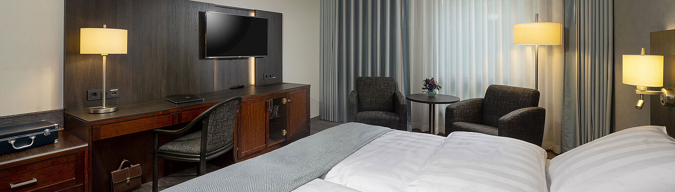 Classic room Elegant double room at Maritim Hotel Bremen with modern furnishings, comfortable beds, and a cozy seating area.