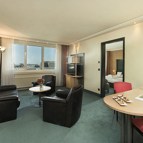 Living area of the Superior Suite at Maritim proArte Hotel Berlin with seating area and window view.