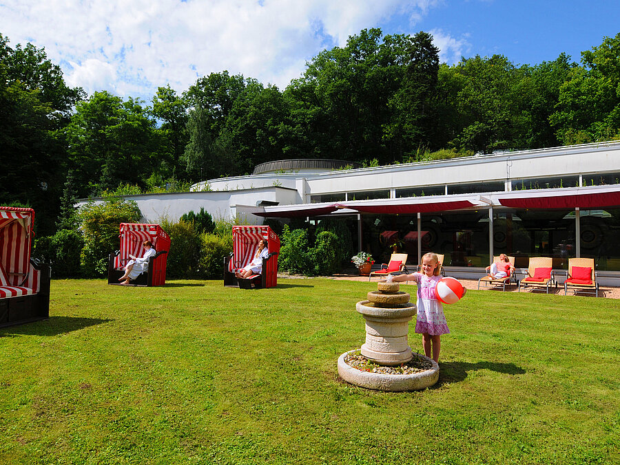 Garden area at Maritim Hotel Bad Wildungen with beach chairs, loungers and play area