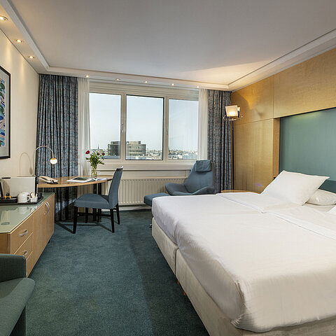 Modernly furnished Superior room at Maritim proArte Hotel Berlin with large bed, desk, artwork, and city view from the window