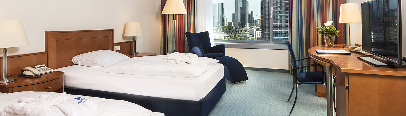 Superior Skyline room Superior room at Maritim Hotel Frankfurt with two single beds, desk, seating area, and stunning skyline view.