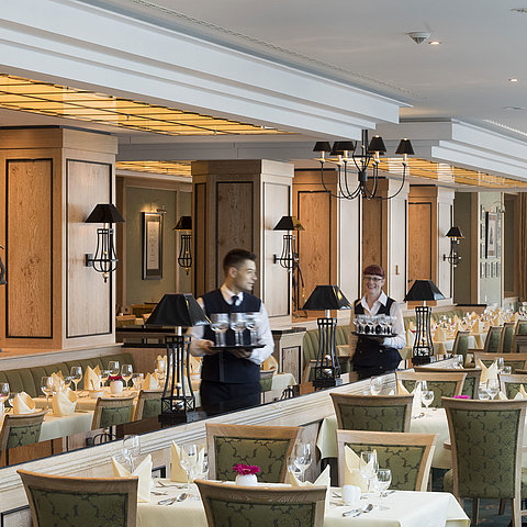 Restaurant 'Wintergarten' at Maritim Hotel Dresden with set tables and friendly staff.
