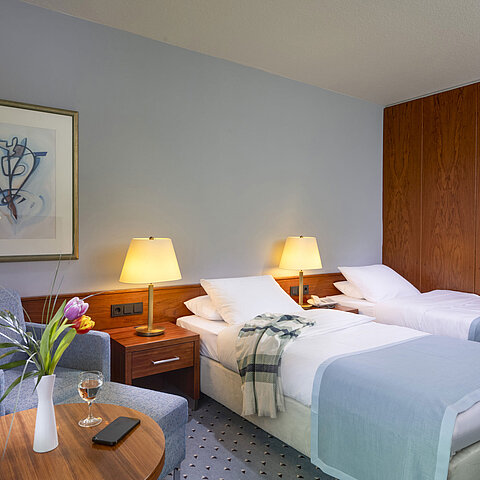 Comfort twin room at Maritim Hotel Darmstadt with two single beds, cozy seating area, and elegant interior design.